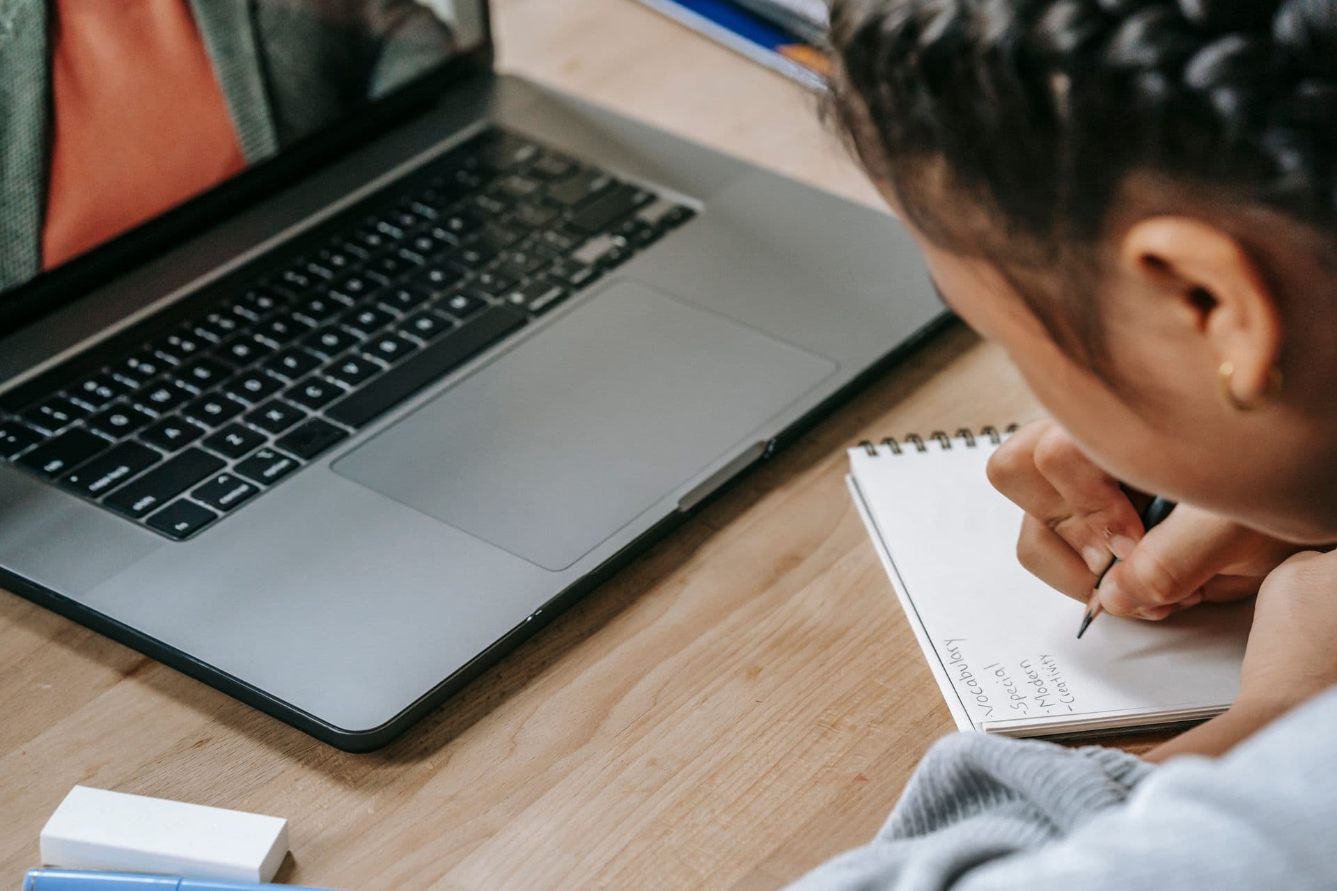 A student taking notes during an online tutoring session